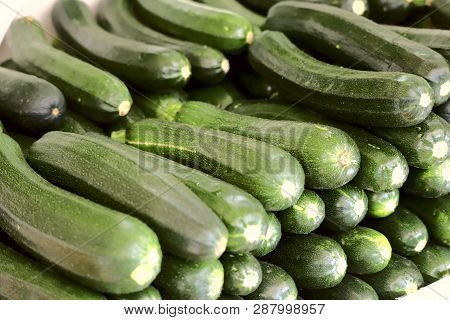 A Group Of Fresh Green Zucchini Stacked In Rows. Cropped Shot, Horizontal, Close-up, Side View. Conc