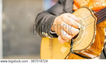 Mariachi Scraping The Strings Of A Mexican Vihuela