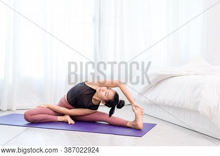 Young Woman Do Yoga In A Bed Room