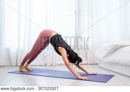 Young Woman Do Yoga In A Bed Room