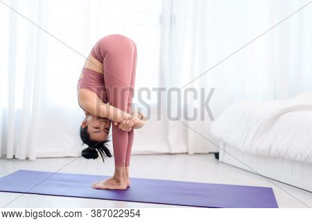 Young Woman Do Yoga In A Bed Room