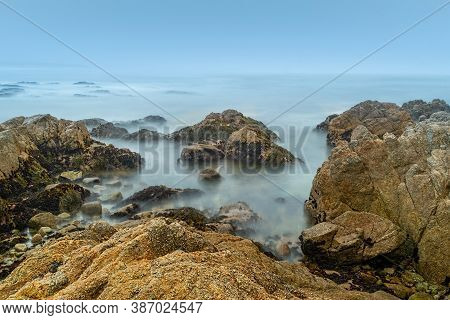 Long Exposure Of The Coastline Of Asilomar State Beach On A Cloudles Blue Sky Evening, California, U