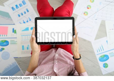 Female Hands Hold Tablet Next To Graphs With Commercial Indicators. Remote Work And Delivery Of Repo
