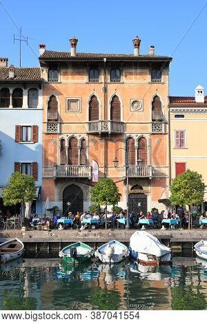 Desenzano, Italy - October 8:  The View Across Boats Moored In The Resort Town Of Desenzano To Cafes