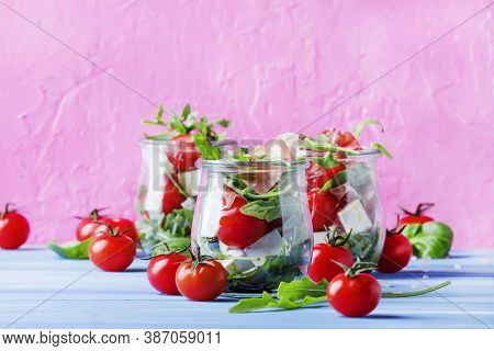 Summer Salad With Arugula, Soft Cheese, Cherry Tomatoes And Prosciutto In Glass Jars, Festive Backgr