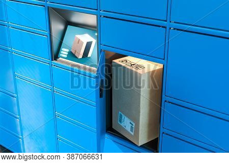 Close Up Of Light Blue Self-service Post Terminal Machine With Touchscreen Monitor And Open Locker W