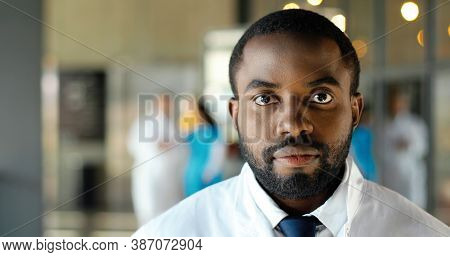Portrait Shot Of African American Young Man Doctor Looking At Camera And Smiling Cheerfully. Handsom