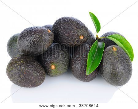 A pile of Hass Avocados with leaves. Horizontal format on a white background with reflection.