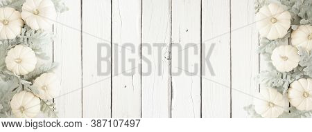 Autumn Double Border Of White Pumpkins And Silver Leaves Over A White Wood Banner Background. Top Vi