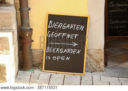 Plaque On The Street. Text In German And English: Beergarden Is Open.