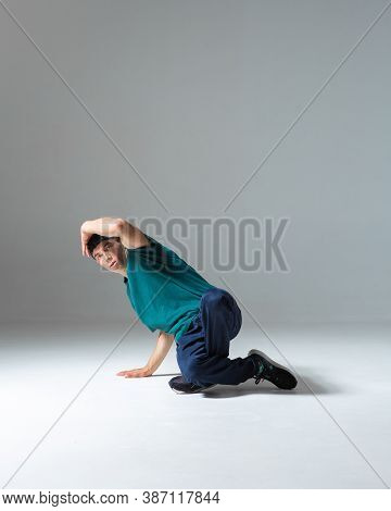 Guy Breakdancer Dancing Lower Break Dance In Studio Isolated On Gray Background