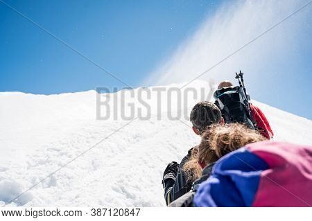 Rope Team Member Point Of View With Mountaineers Walking On Snow And Ice In Sunny Weather.