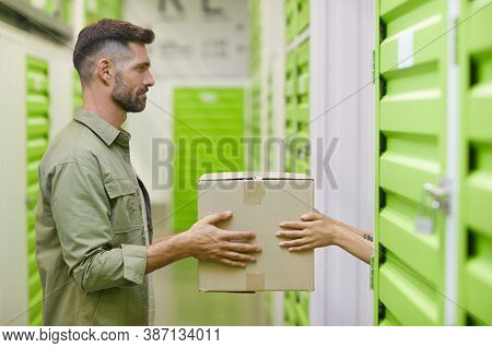 Side View At Handsome Bearded Man Holding Cardboard Box And Handing In To Woman While Packing Self S