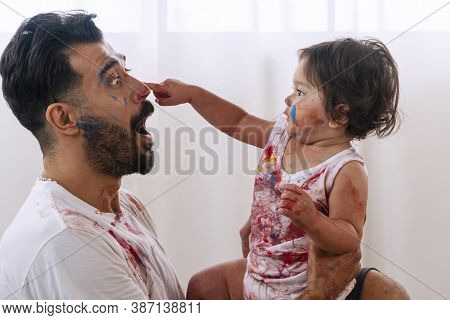 Enjoyment Daughter Playing Color And Holding Hand Color With Her Father At Home. Joyful Man Holding 
