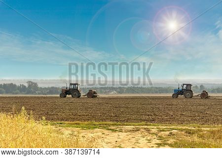 Old Tractors With Seeders On Beautiful Sunny Agricultural Landscape. Farmers Are Sowing Winter Wheat