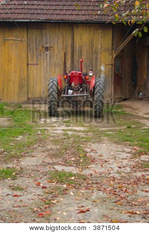 Červený traktor v zahradě