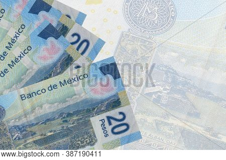20 Mexican Pesos Bills Lies In Stack On Background Of Big Semi-transparent Banknote. Abstract Busine