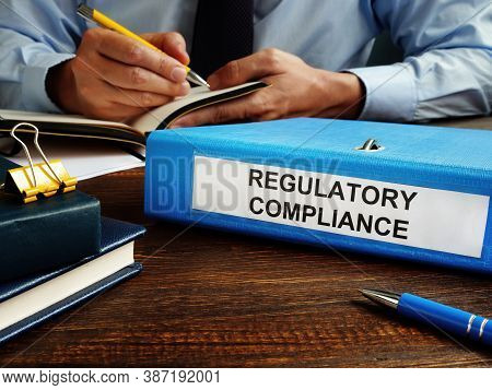 Regulatory Compliance Papers In The Folder And Manager.