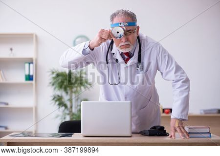 Old male doctor otologist working in the clinic