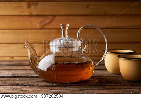 Teapot With Brewed Hot Tea On A Wooden, Cozy Background