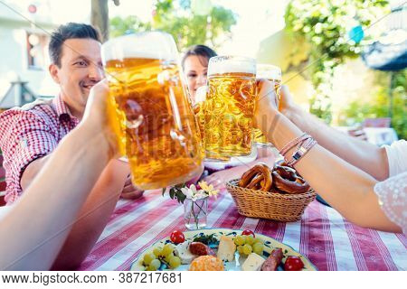 Toasting in Bavarian beer garden, close-up on the glasses