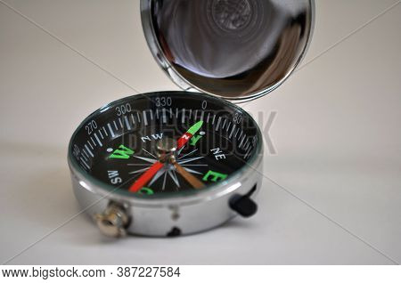 Metal Compass With Colorful Showing Some Black Cardinal Points On White Background With Selective Fo