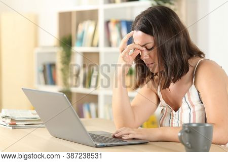 Tired Woman Suffering Eyestrain With A Laptop On A Desk At Home