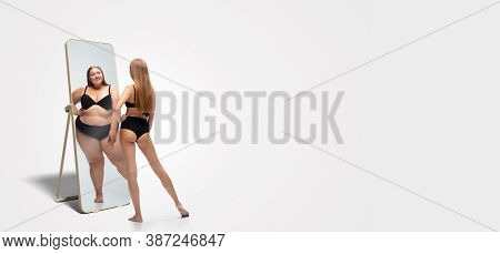 Young Fit, Slim Woman Looking At Fat Girl In Mirrors Reflection On White Background. Thinking Shes N