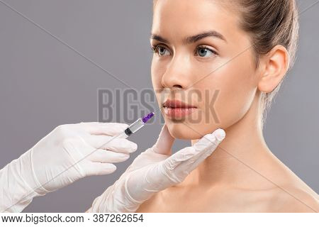 Aesthetic Modern Medicine Concept. Lip Injection For Young Woman Over Grey Studio Background, Closeu