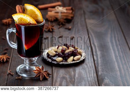 Red Glogg Or Mulled Wine With Orange Slices And Cinnamon Stick On A Dark Wooden Background, Horizont