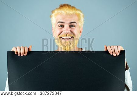Happy Man Holding Empty Sheet Of A Black Paper. Colorful Studio Portrait On Isolated Background. Man