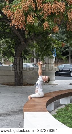 Boy Pulls Two Hands Up To The Branches Of The Tree. Soap Tree In An Urban Environment. The Fruits Of