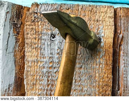 Hammer On A Wooden Handle With A Metal End. Hammer Nails On A Wooden Surface. Metal Nails Are Driven