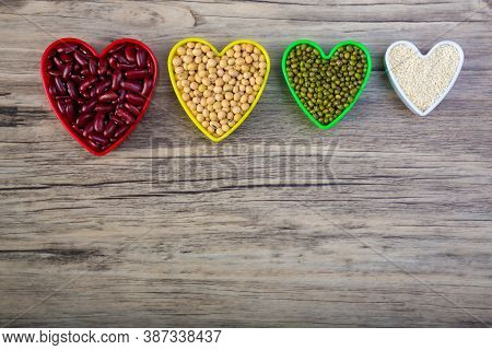 Red Beans In Red Heart Shaped Plastic Bowl. White Sesame Seeds In White Heart Shaped. Soybean In Yel
