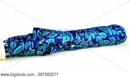 A Folded Compact Umbrella In Dotted Steelblue Color Cover Isolated On White Background