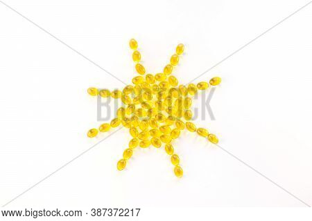 Creative Concept Vitamin D3, Sunshine Vitamin. Capsules Are Laid Out In The Shape Of The Sun On A Wh