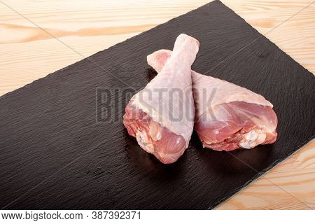 Closeup Two Big Raw Turkey Legs. Turkey Legs On Black Slate Background. Uncooked Raw Turkey Legs On 