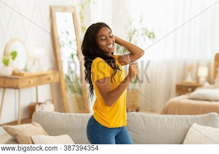 Joyful African American Woman Using Whisk As Microphone To Sing And Dance At Home. Millennial Black 