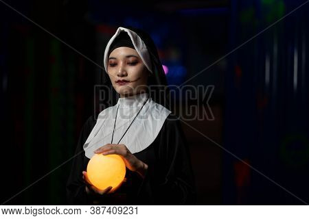 Scary Woman Devil Nun Holding A Cross. Horror Halloween Concept