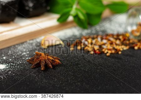 Fresh Black Rye Bread On A Cutting Board With Seasonings Sprinkled With Flour On A Black Wooden Tabl