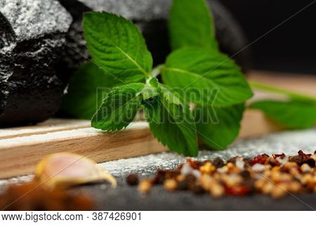Fresh Black Rye Bread On A Cutting Board With Seasonings Sprinkled With Flour On A Black Wooden Tabl
