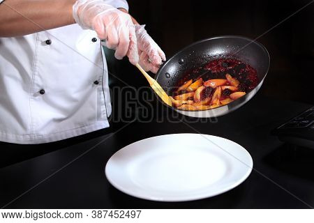 The Chef Puts The Flambe Berries And Fruit On A Plate. Unrecognizable Photo. Flaming Of Fruits And B