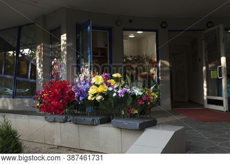 Shop Selling Artificial Flowers. Multicolored Non-natural Flowers Near The Flower Shop.
