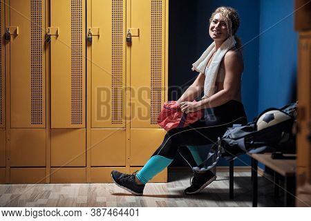 Young girl posing in a locker room in gym before workout 