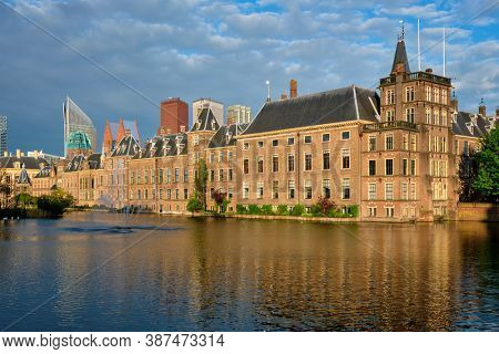 View of the Binnenhof House of Parliament and the Hofvijver lake with downtown skyscrapers in background. The Hague, Netherlands