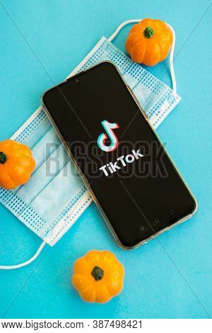 Tver, Russia - September 25, 2020, Medical Mask, Pumpkins And Tik Tok Logo On The Smartphone Screen 