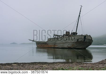 An Old Wooden Soviet Whaling Boat, The Ship Ran Aground On The Bay Shore, The Front Background Is Th