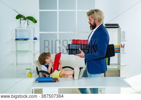 Little Kid Boy Playing To Be Boss On A Business Desk In Office. Business Partners Discussing Plans