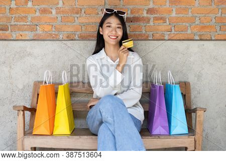 Asian woman sit rested after shopping in a colorful bag and she was happy to go shopping, Happy shop
