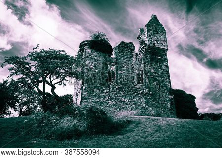 Prominent Piteadie Castle Beside Ornamental Tree In Cut Grass Castle Grounds Under Dramatic Cloudy S